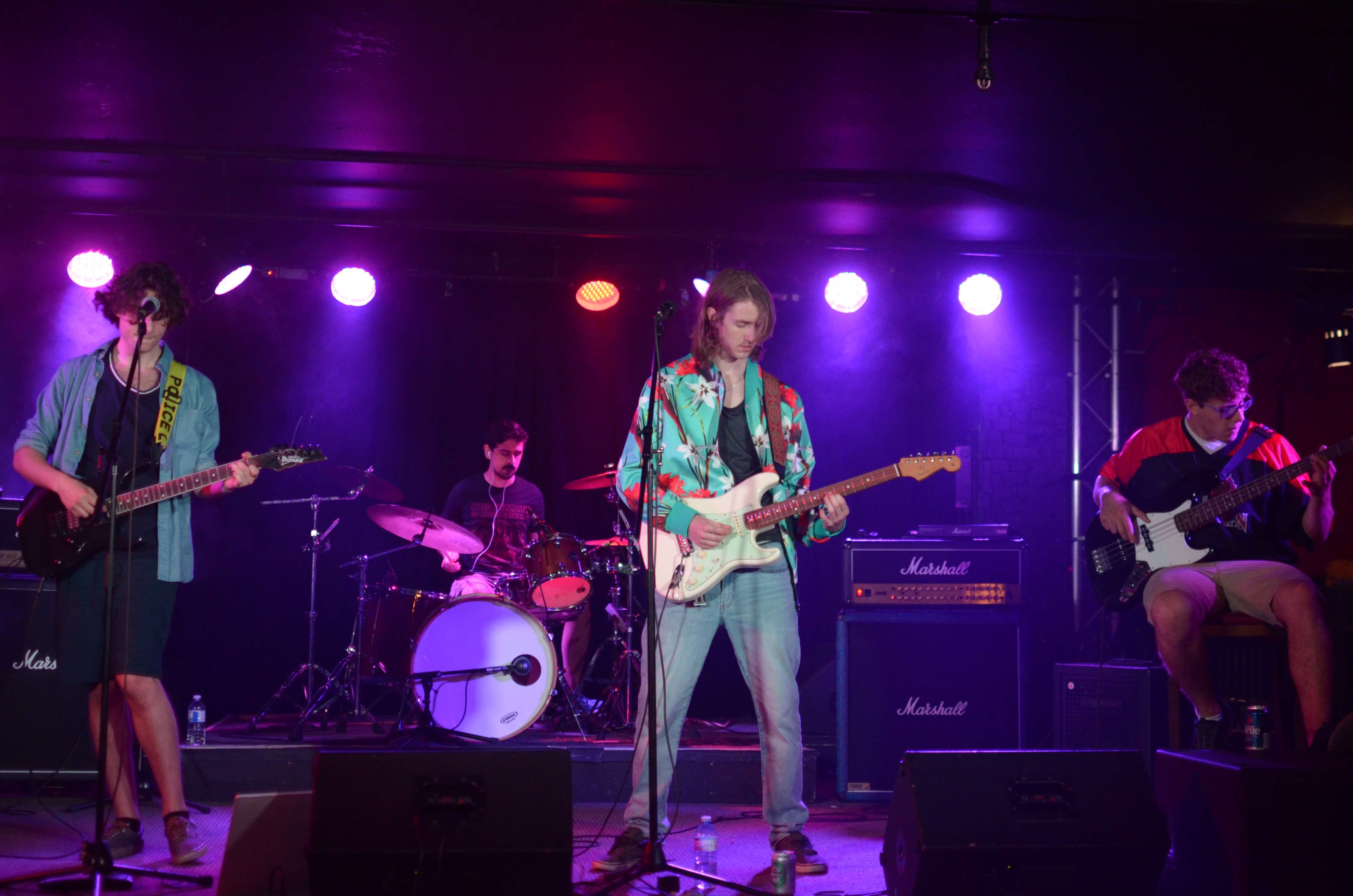 Four band members playing music on stage