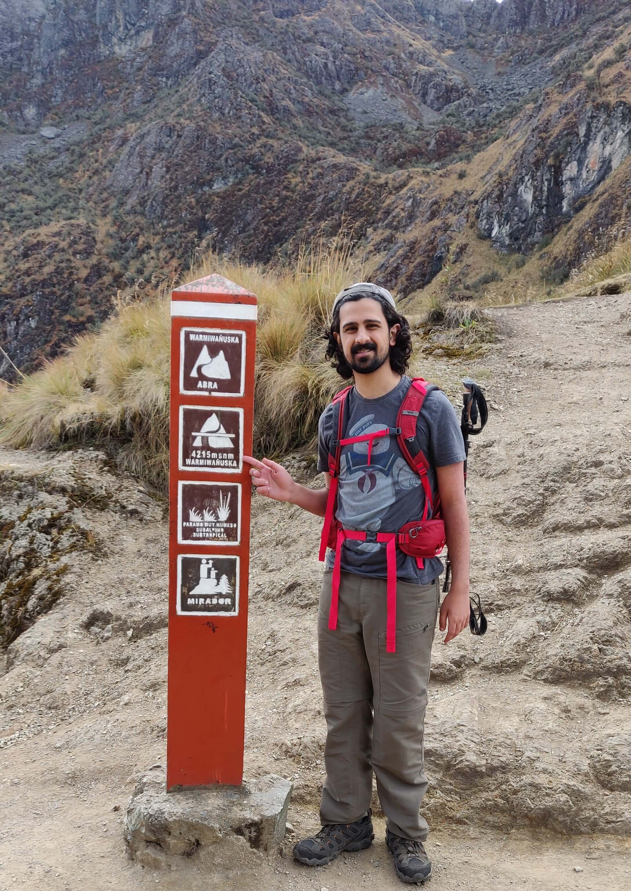 Me on a hiking trail pointing at a sign